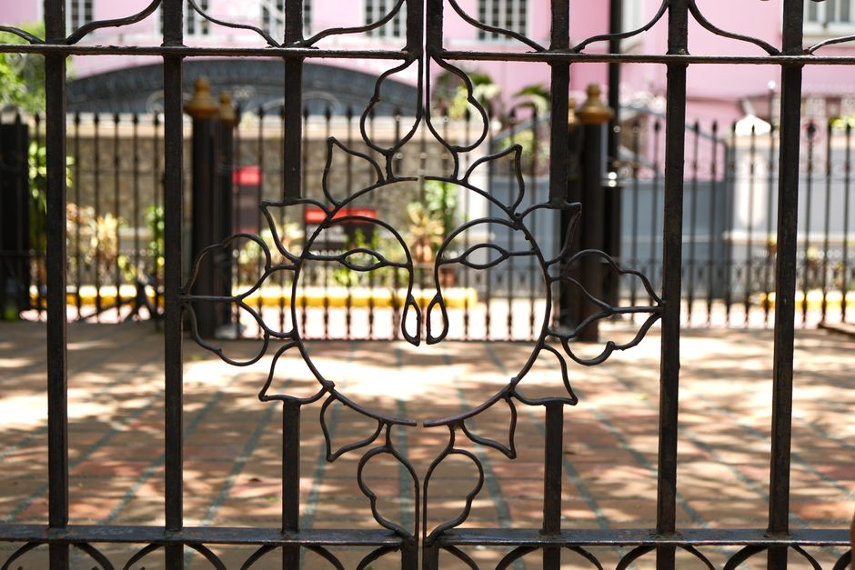 A decorative metal gate beside a brick wall