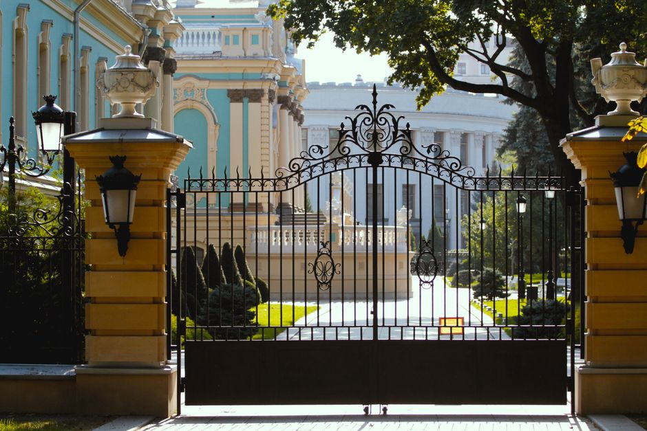 A metal driveway gate with an ornamental top