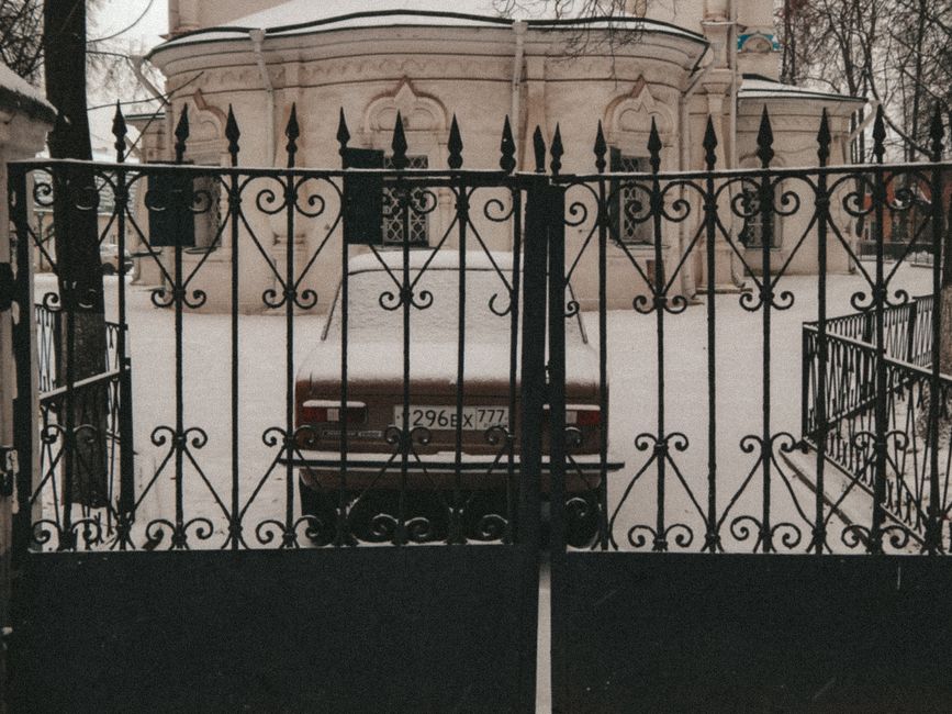 A weathered metal gate beside a garden path
