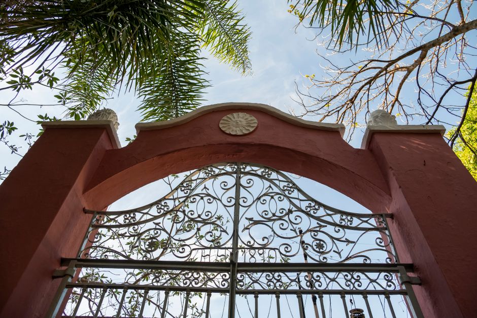 A steel gate leaf standing open at a drive entrance