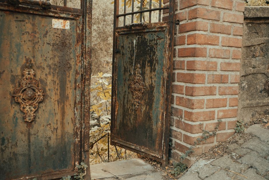 A decorative metal gate beside a brick wall